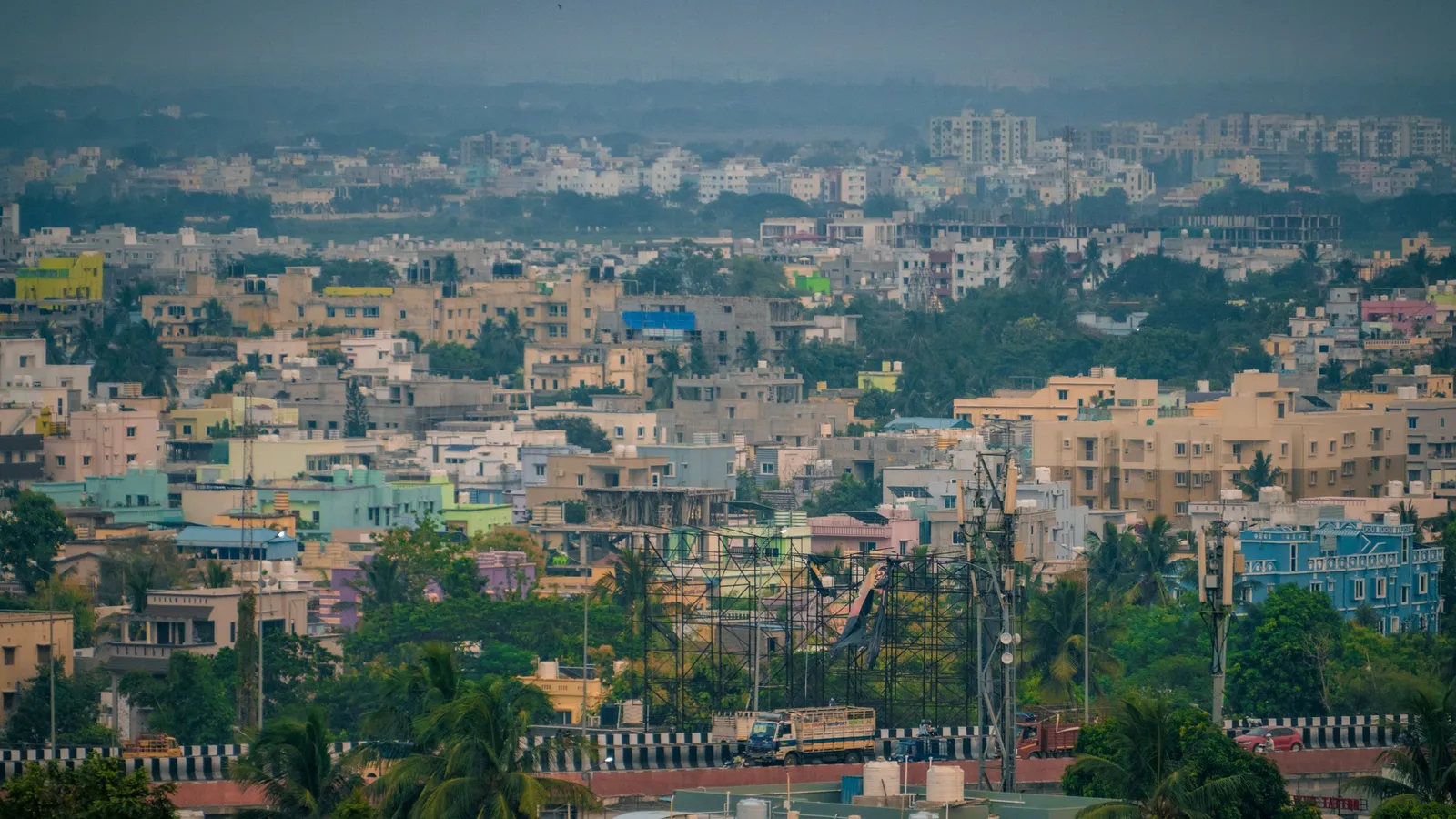 Aerial view of Bhubaneswar city with colourful buildings and green tree cover stretching to the horizon