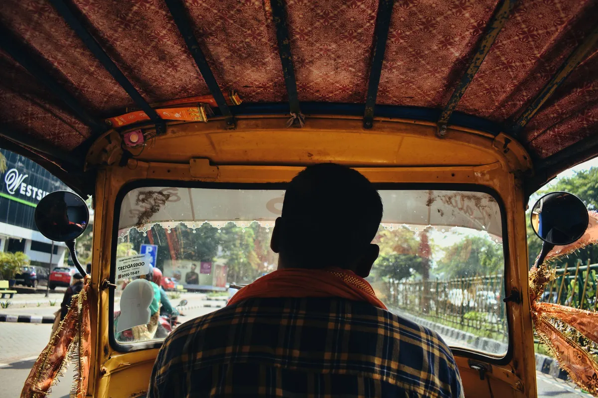 View from the back seat of an auto rickshaw driving through a city street in Bhubaneswar, Odisha